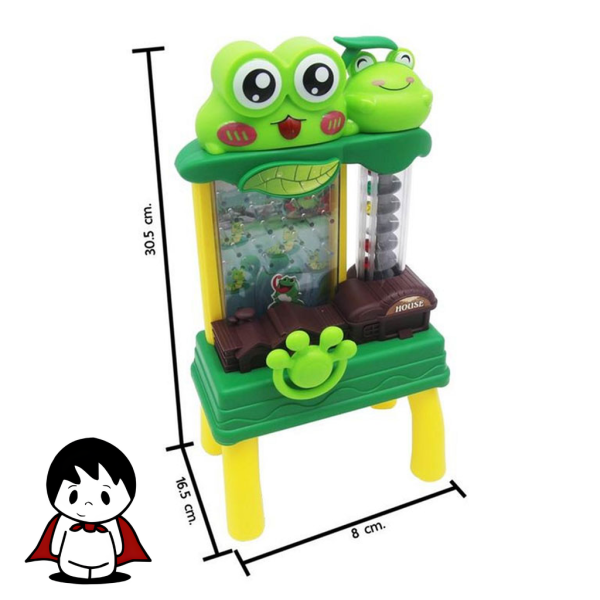 یک اسباببازی پلاستیکی سبز رنگ به شکل قورباغهای با دهان باز که روی یک سطح روشن قرار گرفته است. در کنار قورباغه، چندین سکه پلاستیکی رنگارنگ دیده میشود که آماده پرتاب شدن هستند. تصویر، حس یک بازی شاد، پرانرژی و آموزشی را برای کودکان خردسال القا میکند.